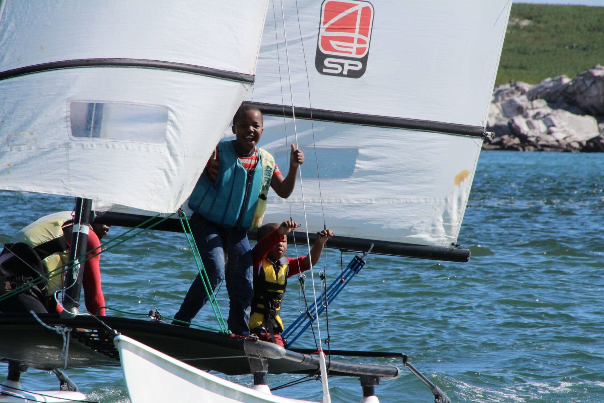 Young sailors in life jackets on a Hobie during a lesson